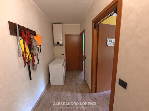 Corridoio con zona lavanderia, scaldabagno e accesso alle camere