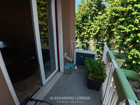 Balcone del soggiorno con vista sul verde e unità esterna del climatizzatore